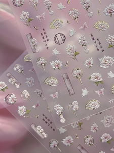 Vue macro de stickers ongles 5D en relief avec pivoines et éventails chinois anciens