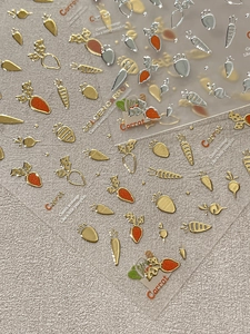 Vista macro di adesivi per unghie a carota 3D con texture metallica oro e argento