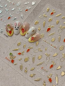 Dettaglio di adesivi per unghie a rilievo 3D con carota e coniglio in oro e argento