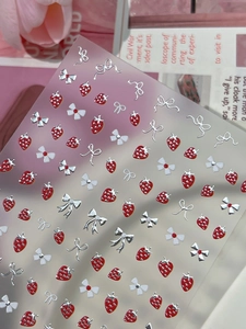 Macro detail of 3D embossed nail stickers featuring strawberries and bows for manicure