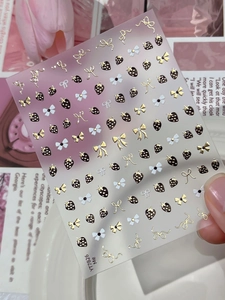 Detail of YT7826 nail art stickers with gold bows and strawberry patterns on pink background