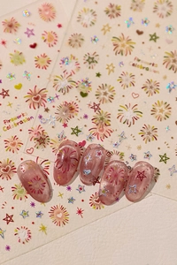 Macro shot of laser glitter fireworks nail stickers on pink cat-eye finished fake nails
