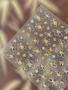 Détails de stickers nail art fleurs et nœuds en relief avec accents dorés et argentés