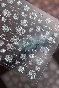 Vista macro di adesivi 3D argento per unghie con disegni di fuochi d'artificio