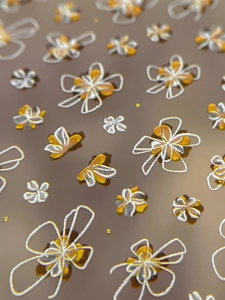 Vue détaillée d'autocollants 3D pour ongles aux motifs de fleurs et nœuds dorés