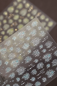 Dettaglio macro di adesivi per unghie 3D olografici argento con motivi a fuochi d'artificio