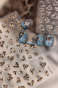 Detailed view of leopard heart nail stickers with gold and silver foil accents
