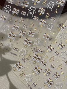 Dettaglio macro di adesivi per unghie 3D con danza del leone e calligrafia dorata