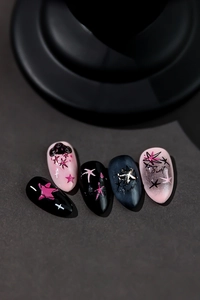 Close-up of sweet cool style nail art stickers featuring pink stars and cross patterns