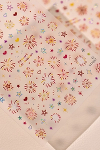 Macro detail of fireworks and star patterns on laser gold and red nail art stickers