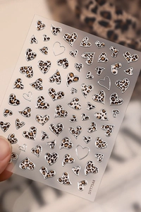 Macro shot of leopard print heart nail stickers on transparent film, model SIYT7544