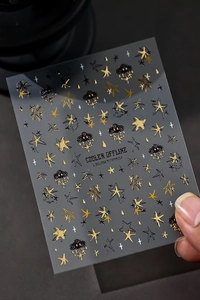 Detail of 3D embossed nail art stickers with metallic gold stars and cool slogans