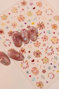 Detail of fireworks and heart nail stickers with laser effect on pink ombre nails