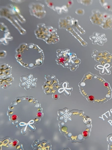Macro view of 5D embossed snowflake and bowknot nail stickers with metallic gold finish