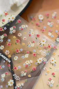 Macro détaillée de stickers nail art fleurs en relief 3D aux couleurs pastel sur film transparent