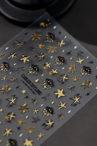 Detail of embossed black and gold nail art stickers with star, cloud and celestial patterns
