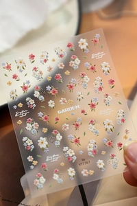 Gros plan de stickers à ongles 5D en relief avec motifs de marguerites et textures