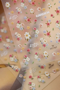 Détail d'autocollants 5D pour ongles avec des motifs de fleurs de jardin colorées en relief