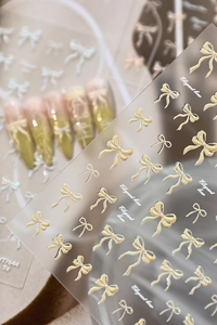Detailed macro view of 3D embossed shell bow nail stickers with holographic pearl finish