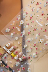 Gros plan d'autocollants pour ongles aux motifs de marguerites et fleurs violettes