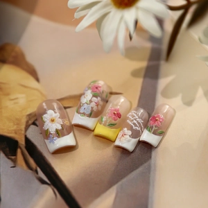 Faux ongles 3D à fleurs gaufrées avec French tips sur fond artistique chaleureux