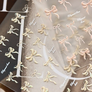 3D bow nail stickers with pearl finish in white, champagne, and soft pink tones