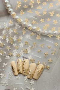 Macro shot of 3D embossed gold and silver flower nail stickers on nude nail tips