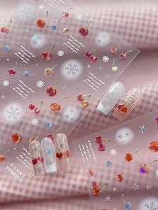 Detail showing 3D embossed cherry and snowflake nail stickers with relief texture