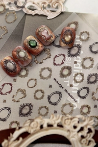 Detailed macro view of vintage 3D nail art gems with embossed metallic frames and stones