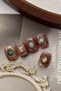 Detailed macro view of baroque nail art featuring marble texture and embossed metal frames