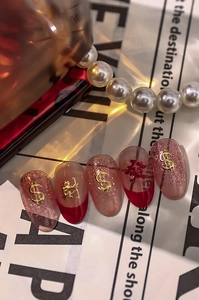 Macro view of press-on nails with golden currency symbols and festive character charms