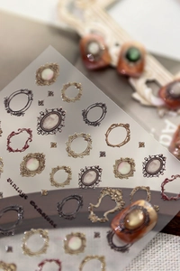 Macro detail of vintage 3D embossed nail art stickers featuring ornate metallic frames
