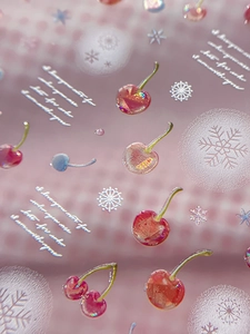 Macro shot of 3D cherry and snowflake nail stickers with iridescent glitter texture