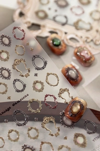 Macro detail of embossed vintage gemstone frames nail art sticker YT7607 in gold and bronze