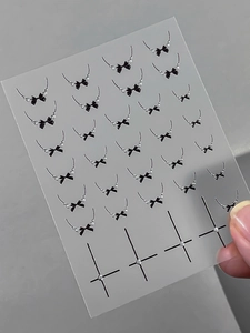 Detail showing 3D embossed black bows and star motifs on transparent nail art stickers