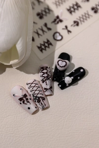 Detailed view of ballet bow press-on nails with 3D heart and criss-cross ribbon accents