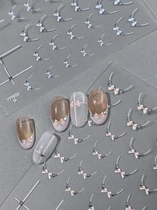 Detail of 3D embossed bow nail art stickers in light blue and pink on various manicured nails