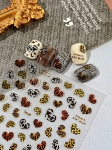 Macro detail of heart-shaped animal print nail stickers with leopard and tiger textures