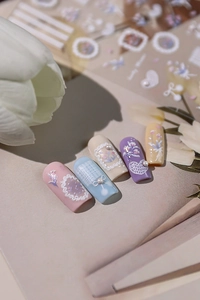 Close-up of 3D embossed floral nail art stickers with delicate pearls and lace patterns