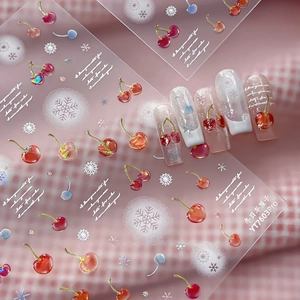 Winter cherry and snowflake nail art stickers with glitter finish on a light pink background