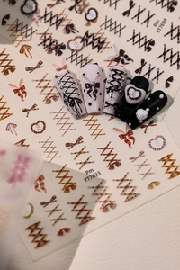Detail of ballet bow nail stickers with pearls and heart designs in brown and beige
