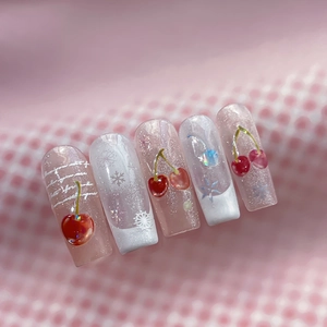 Pink glitter press-on nails with 3D cherry accents and white snowflake patterns