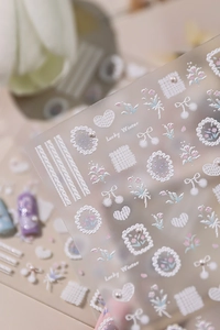 Macro view of 3D embossed nail stickers with Lucky Winter knit texture and floral designs