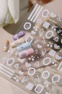Macro detail of 3D embossed floral nail stickers with pearl textures and pastel patterns