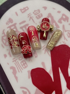 Détail de faux ongles du Nouvel An rouge et champagne avec caractères chinois de chance