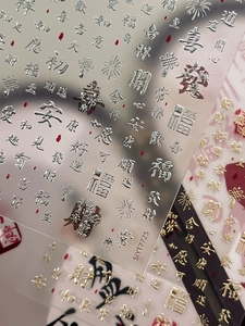Détail d'autocollants 3D pour ongles avec caractères chinois or et argentés