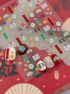 Detail of 3D New Year nail art stickers featuring mahjong tiles and lucky Chinese charms