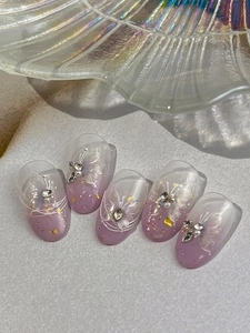 Detail of lavender gradient press-on nails with white butterfly and pearl embellishments