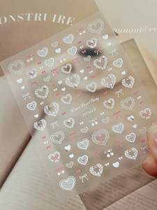 Detail von Winter Pearl Party Nagelaufklebern mit rosa Schleifen und 3D Perlenherzen