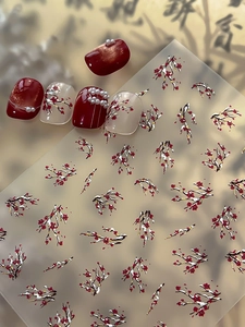 Detail of winter plum blossom nail stickers with red floral patterns and pearl accents